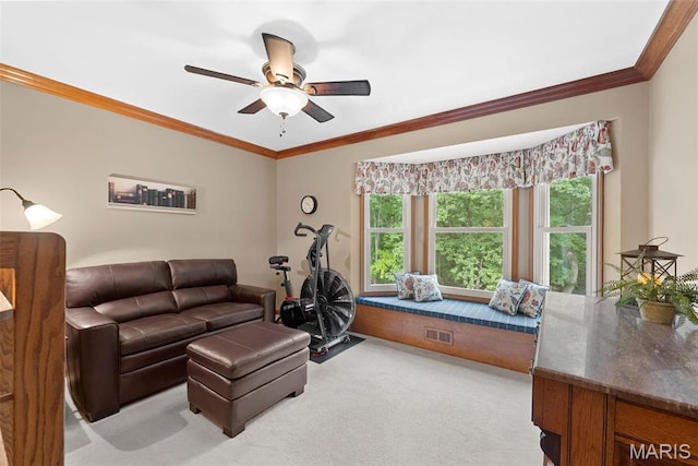 living area featuring carpet floors, ceiling fan, plenty of natural light, and ornamental molding