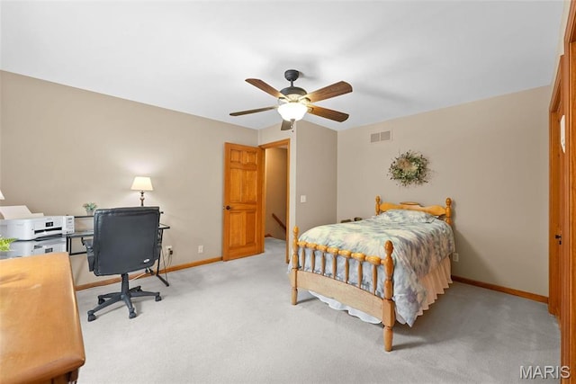 bedroom with light carpet, baseboards, an office area, and a ceiling fan