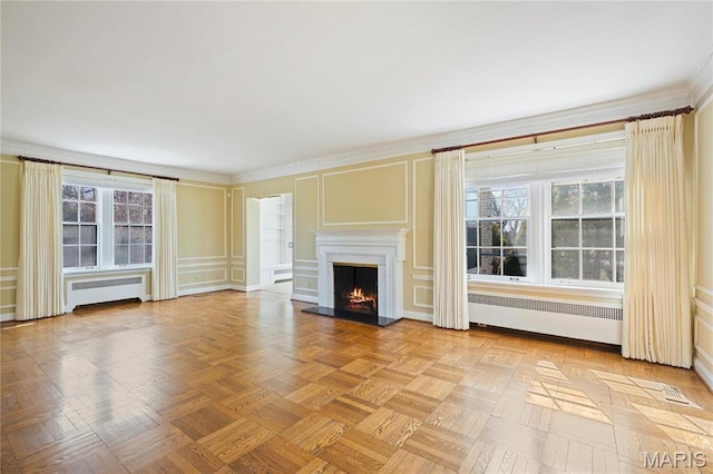 910 Kent Rd, Ladue, MO 63124 - unfurnished living room with radiator heating unit, a decorative wall, a lit fireplace, and crown molding