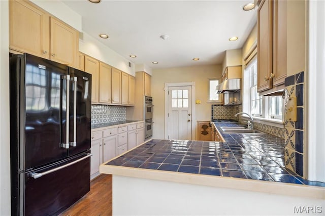910 Kent Rd, Ladue, MO 63124 - kitchen with freestanding refrigerator, a peninsula, double oven, light brown cabinets, and decorative backsplash