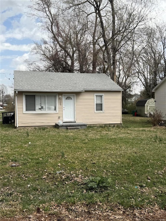 view of front of property with a front lawn and a shingled roof