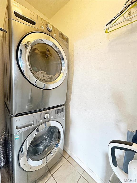 703 S Main St, Troy, IL 62294 - laundry room with estacked washer and dryer, tile patterned flooring, and baseboards