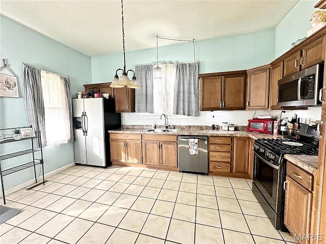703 S Main St, Troy, IL 62294 - kitchen featuring stainless steel appliances, a sink, backsplash, light tile patterned flooring, and pendant lighting