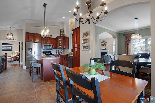 2009 Weber Heights Dr, Washington, MO 63090 - dining area with a chandelier, arched walkways, ornamental molding, a fireplace, and vaulted ceiling
