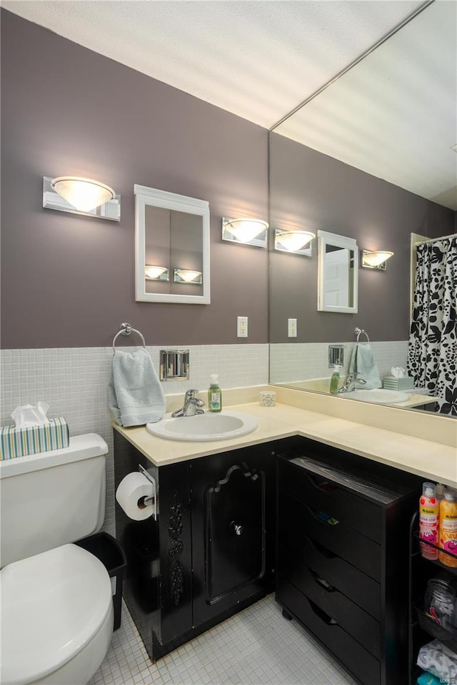 11921 Villa Dorado Dr Unit F, Saint Louis, MO 63146 - bathroom featuring tile patterned floors, vanity, toilet, tile walls, and a wainscoted wall