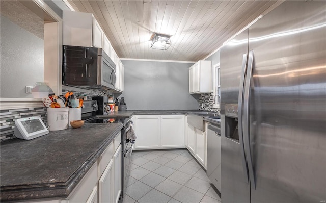 15105 Transit Rd, Saint Robert, MO 65584 - kitchen with stainless steel appliances, light tile patterned floors, backsplash, dark countertops, and white cabinets