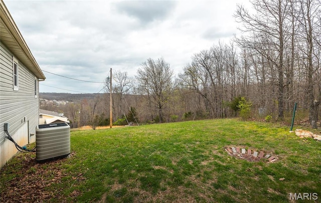 15105 Transit Rd, Saint Robert, MO 65584 - view of green lawn with central AC unit and a view of trees