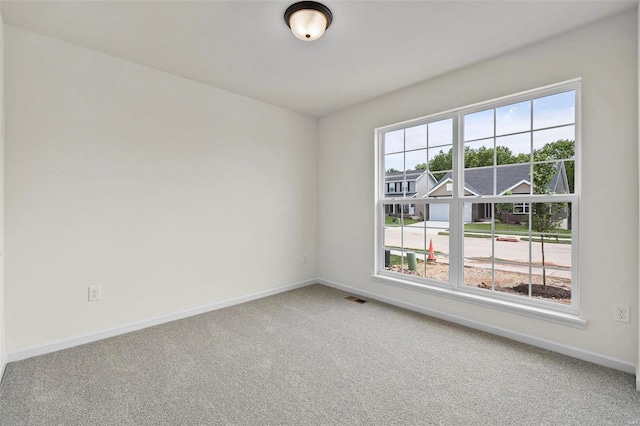 carpeted spare room featuring baseboards