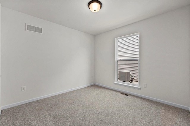 empty room featuring light carpet and baseboards