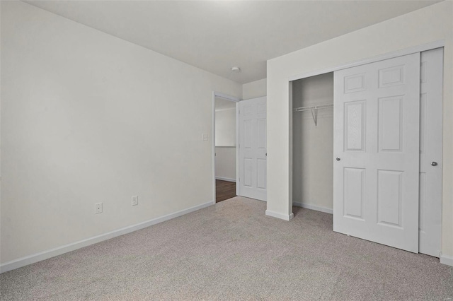 unfurnished bedroom featuring carpet floors, baseboards, and a closet