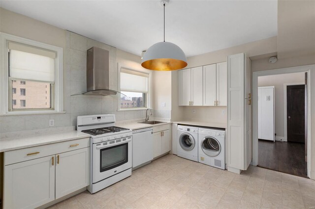 4440 Lindell Blvd Unit 701, Saint Louis, MO 63108 - kitchen with white appliances, washing machine and clothes dryer, wall chimney exhaust hood, a sink, and light countertops
