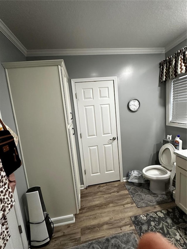 610 W Maple St, Advance, MO 63730 - bathroom featuring wood finished floors, crown molding, vanity, toilet, and a textured ceiling