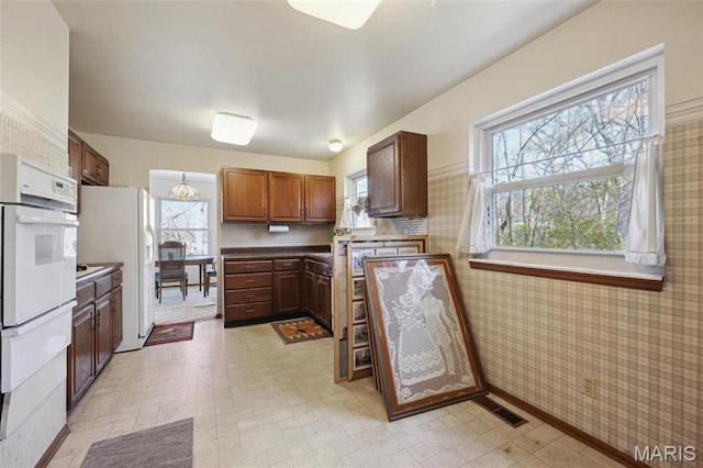 32 Oak Forest Dr, Saint Charles, MO 63303 - kitchen with white appliances, a warming drawer, light floors, and wallpapered walls
