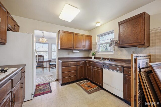 32 Oak Forest Dr, Saint Charles, MO 63303 - kitchen featuring white appliances, dark countertops, plenty of natural light, and light flooring