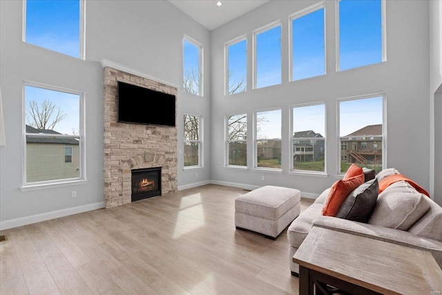 5 Canebrake Ct, Wentzville, MO 63385 - living room featuring a towering ceiling, wood finished floors, baseboards, and a stone fireplace