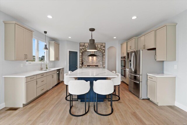 5 Canebrake Ct, Wentzville, MO 63385 - kitchen featuring stainless steel appliances, a sink, light wood-style flooring, light countertops, and a kitchen island