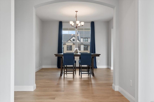 5 Canebrake Ct, Wentzville, MO 63385 - dining room with arched walkways, a chandelier, wood finished floors, and baseboards