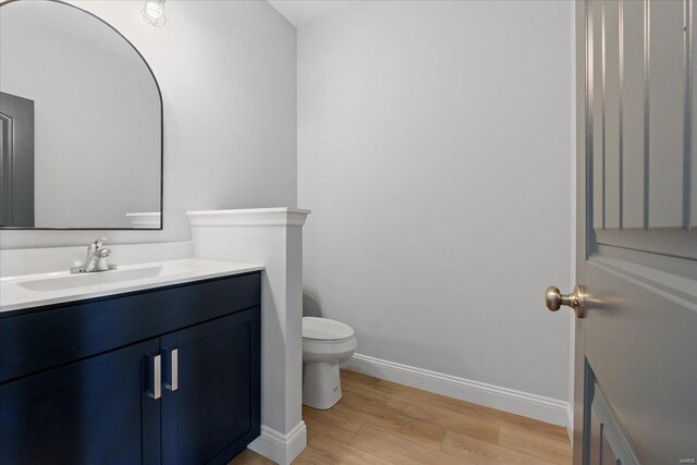 5 Canebrake Ct, Wentzville, MO 63385 - half bathroom featuring wood finished floors, baseboards, vanity, and toilet