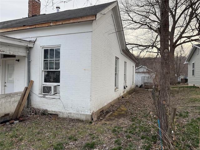 600 N 7th St, Louisiana, MO 63353 - view of side of home featuring brick siding, a chimney, and cooling unit