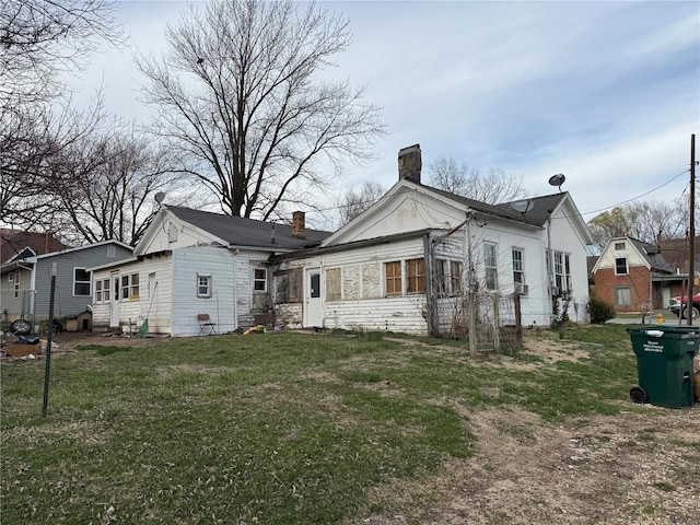 600 N 7th St, Louisiana, MO 63353 - back of property with a chimney, stone siding, entry steps, and a yard