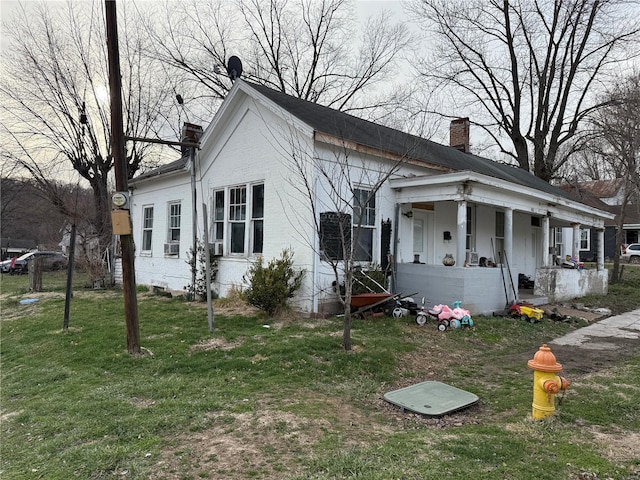 600 N 7th St, Louisiana, MO 63353 - view of front facade with a chimney, covered porch, and a front yard