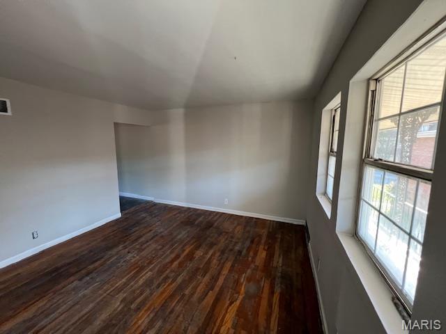 8440 N Broadway N, Saint Louis, MO 63147 - spare room featuring wood finished floors, baseboards, and vaulted ceiling