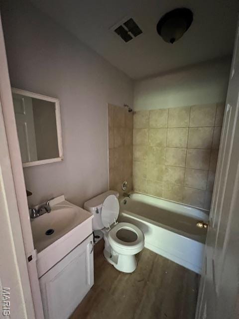 8440 N Broadway N, Saint Louis, MO 63147 - bathroom with wood finished floors, vanity, toilet, and tub / shower combination