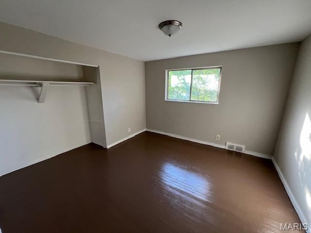 8440 N Broadway N, Saint Louis, MO 63147 - unfurnished bedroom featuring a closet, wood finished floors, and baseboards