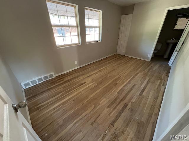 8440 N Broadway N, Saint Louis, MO 63147 - unfurnished bedroom featuring wood finished floors and baseboards