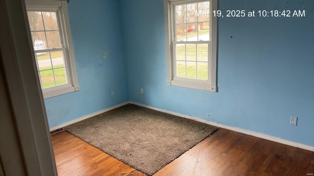 unfurnished room with baseboards and wood finished floors