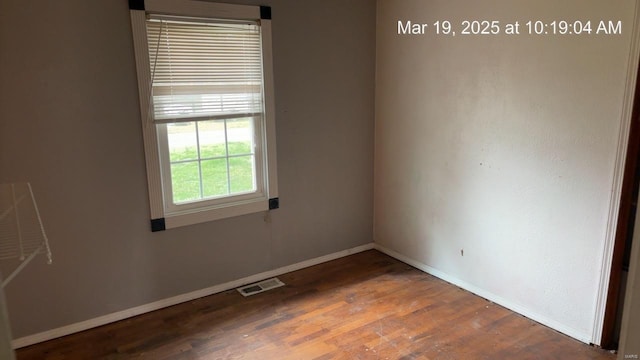 spare room featuring baseboards and wood finished floors