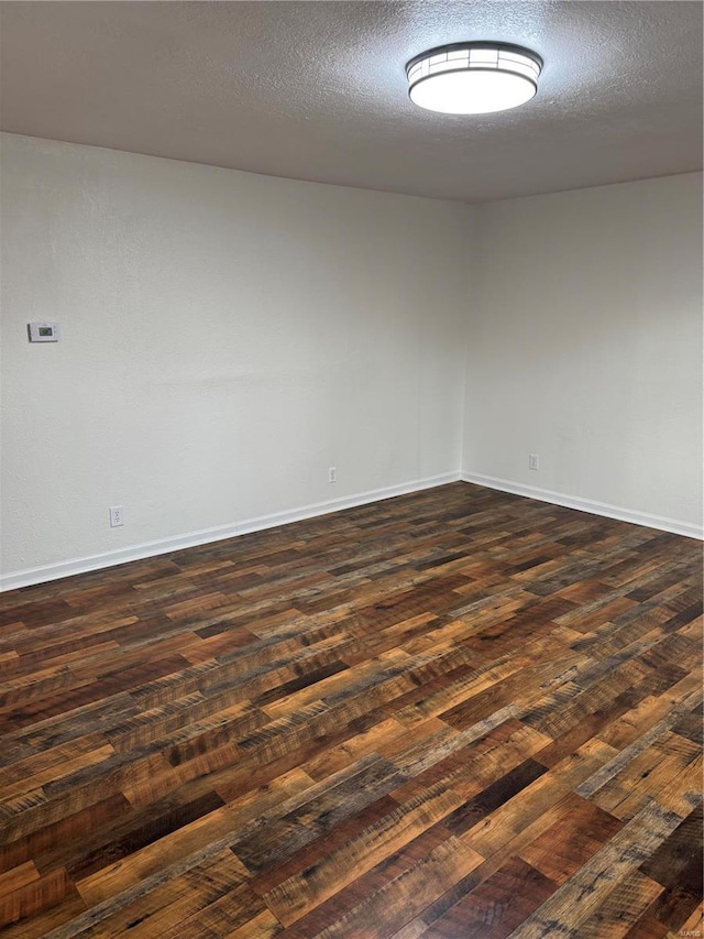 2012 Bradley, Kennett, MO 63857 - unfurnished room with dark wood-style flooring, baseboards, and a textured ceiling