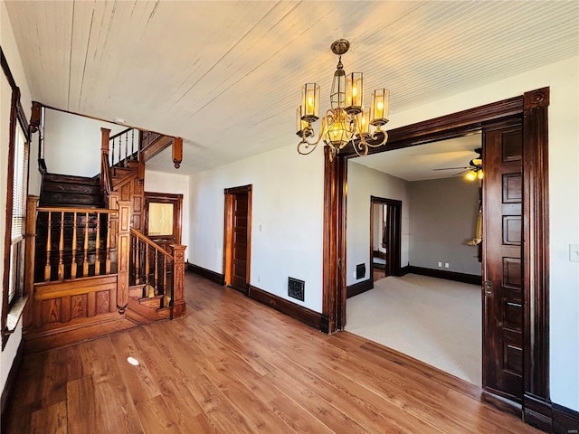 230 Lahaye St, Saint Genevieve, MO 63670 - unfurnished room with a chandelier, stairs, wood finished floors, baseboards, and a ceiling fan