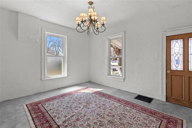 407 N Humboldt St, Marine, IL 62061 - foyer entrance with a chandelier, carpet floors, and a textured wall