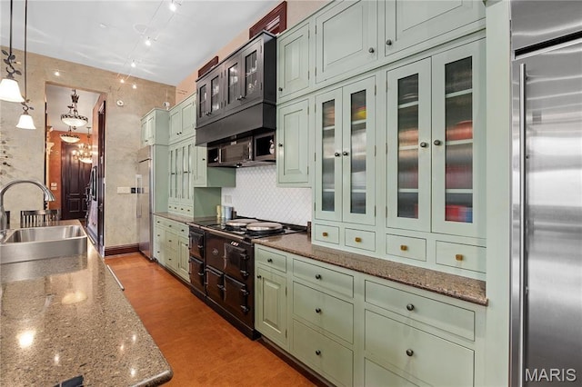 3520 Galt House Dr, Saint Charles, MO 63301 - kitchen with green cabinetry, a sink, high end fridge, decorative backsplash, and glass insert cabinets