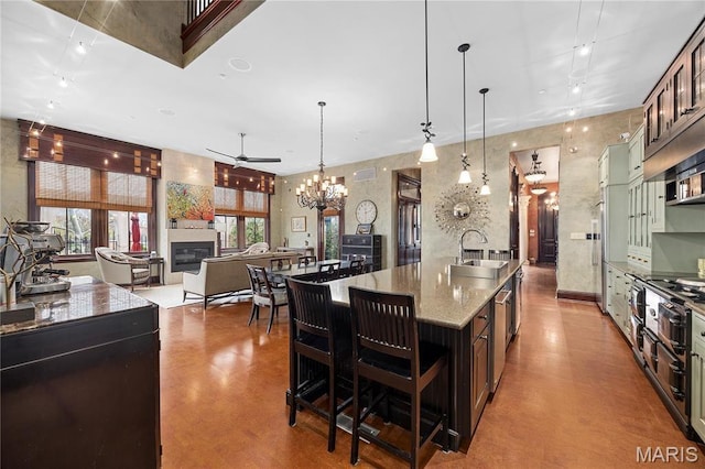 3520 Galt House Dr, Saint Charles, MO 63301 - kitchen with a sink, ceiling fan, a large island with sink, a glass covered fireplace, and a chandelier