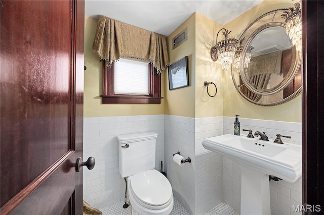 3520 Galt House Dr, Saint Charles, MO 63301 - half bath featuring tile walls, tile patterned flooring, a wainscoted wall, toilet, and a chandelier