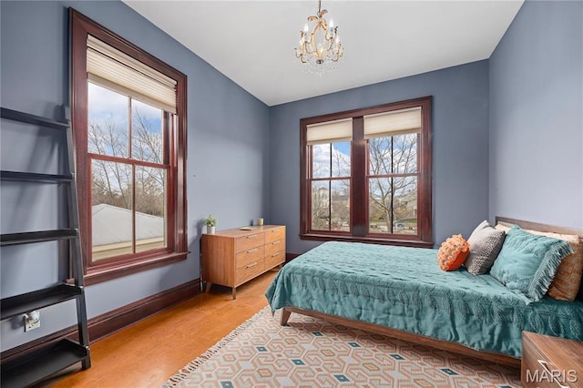 3520 Galt House Dr, Saint Charles, MO 63301 - bedroom with a chandelier, multiple windows, wood finished floors, and baseboards
