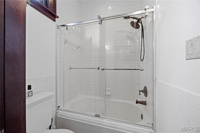 3520 Galt House Dr, Saint Charles, MO 63301 - full bathroom featuring tile walls, shower / bath combination with glass door, toilet, and wainscoting