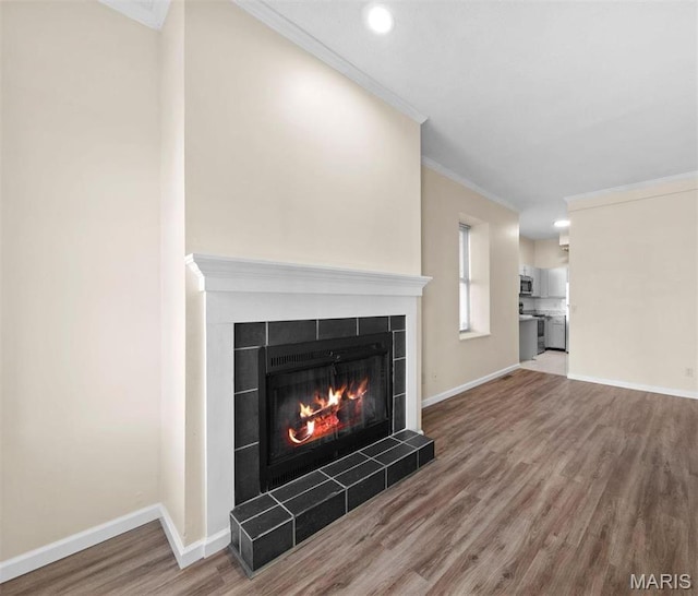 4319 Lindell Blvd Unit A, Saint Louis, MO 63108 - unfurnished living room with a tiled fireplace, wood finished floors, crown molding, and recessed lighting