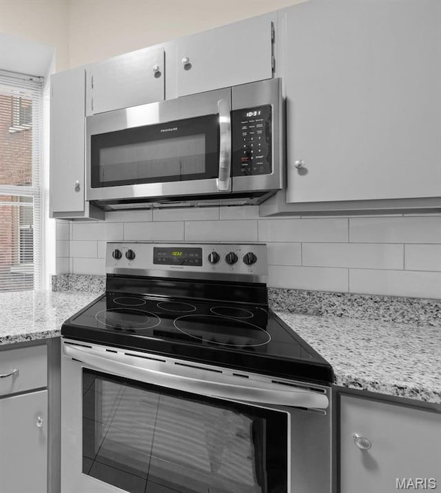 4319 Lindell Blvd Unit A, Saint Louis, MO 63108 - kitchen with appliances with stainless steel finishes, decorative backsplash, and light stone countertops