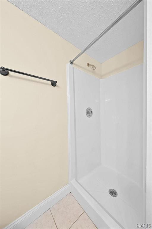 4319 Lindell Blvd Unit A, Saint Louis, MO 63108 - bathroom featuring tile patterned floors, a textured ceiling, and a shower