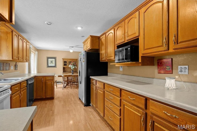 830 Wayne St, Carlyle, IL 62231 - kitchen with dishwasher, stainless steel fridge with ice dispenser, ceiling fan, light countertops, and brown cabinetry