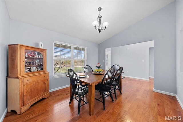140 Shumard Oak Dr, Troy, MO 63379 - dining area featuring vaulted ceiling, baseboards, light wood-style floors, and a chandelier