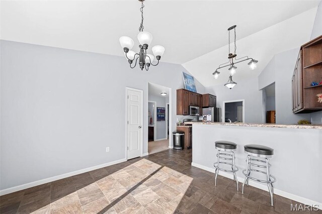 140 Shumard Oak Dr, Troy, MO 63379 - kitchen with appliances with stainless steel finishes, vaulted ceiling, light countertops, open shelves, and a breakfast bar