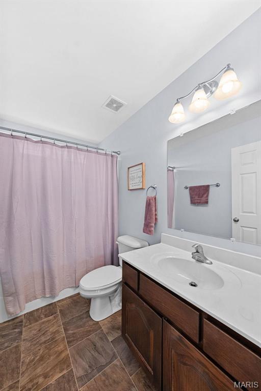 140 Shumard Oak Dr, Troy, MO 63379 - bathroom with vanity, toilet, lofted ceiling, and a shower with shower curtain