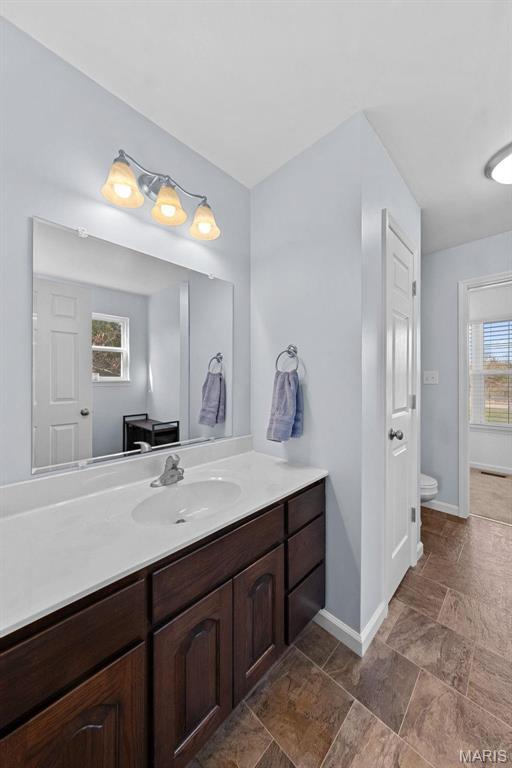 140 Shumard Oak Dr, Troy, MO 63379 - bathroom with baseboards, toilet, vanity, and stone finish flooring