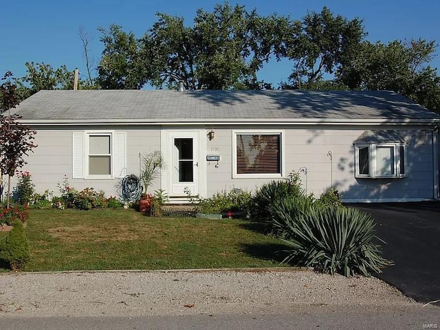 single story home featuring a front lawn and roof with shingles