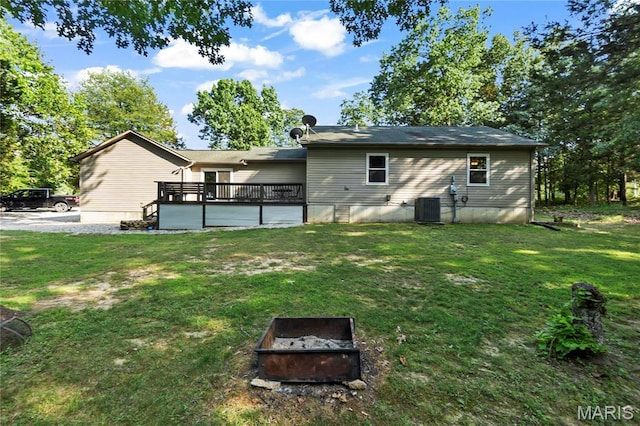 5057 Port Perry Dr, Perryville, MO 63775 - rear view of property featuring central air condition unit, a lawn, an outdoor fire pit, and a wooden deck