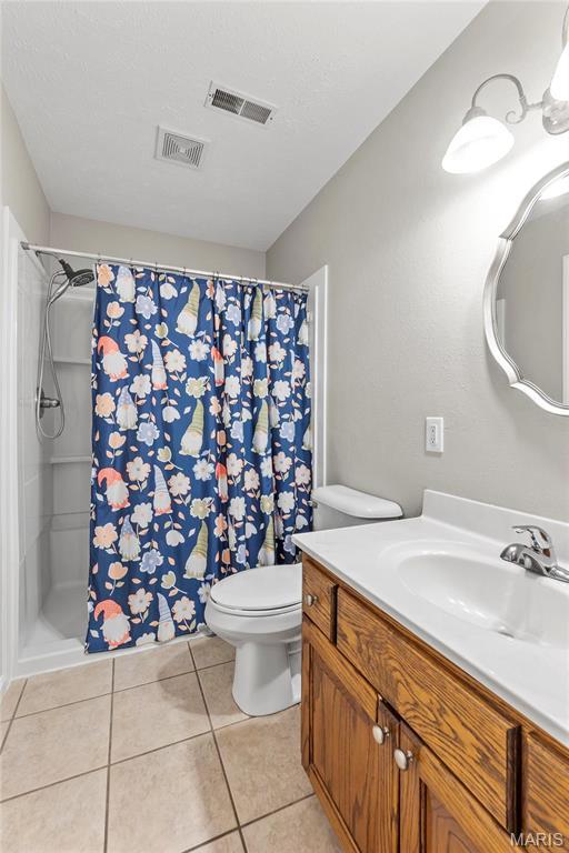 5057 Port Perry Dr, Perryville, MO 63775 - bathroom with toilet, vanity, tile patterned flooring, and curtained shower